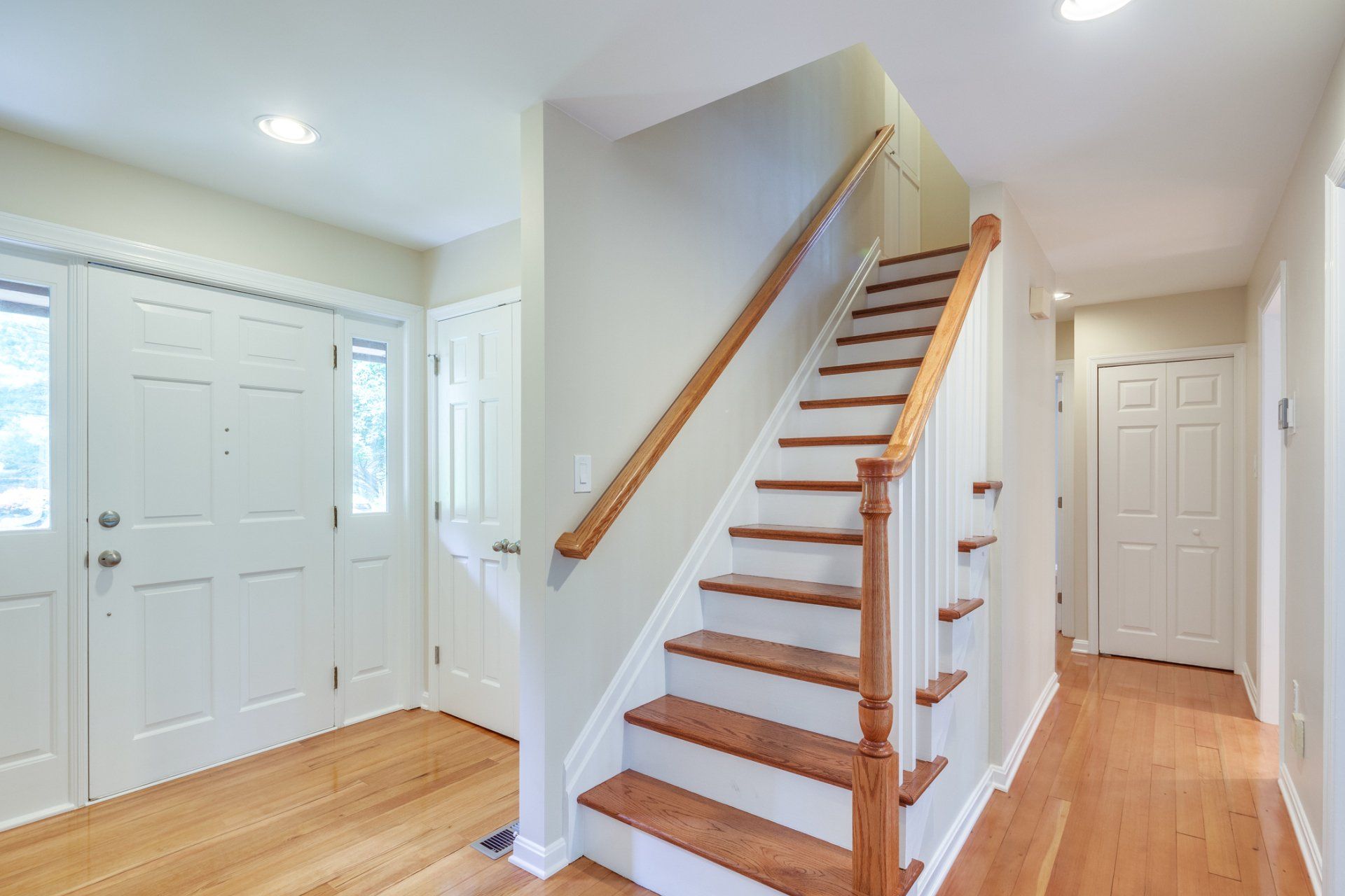 A hallway with stairs leading up to the second floor of a house.