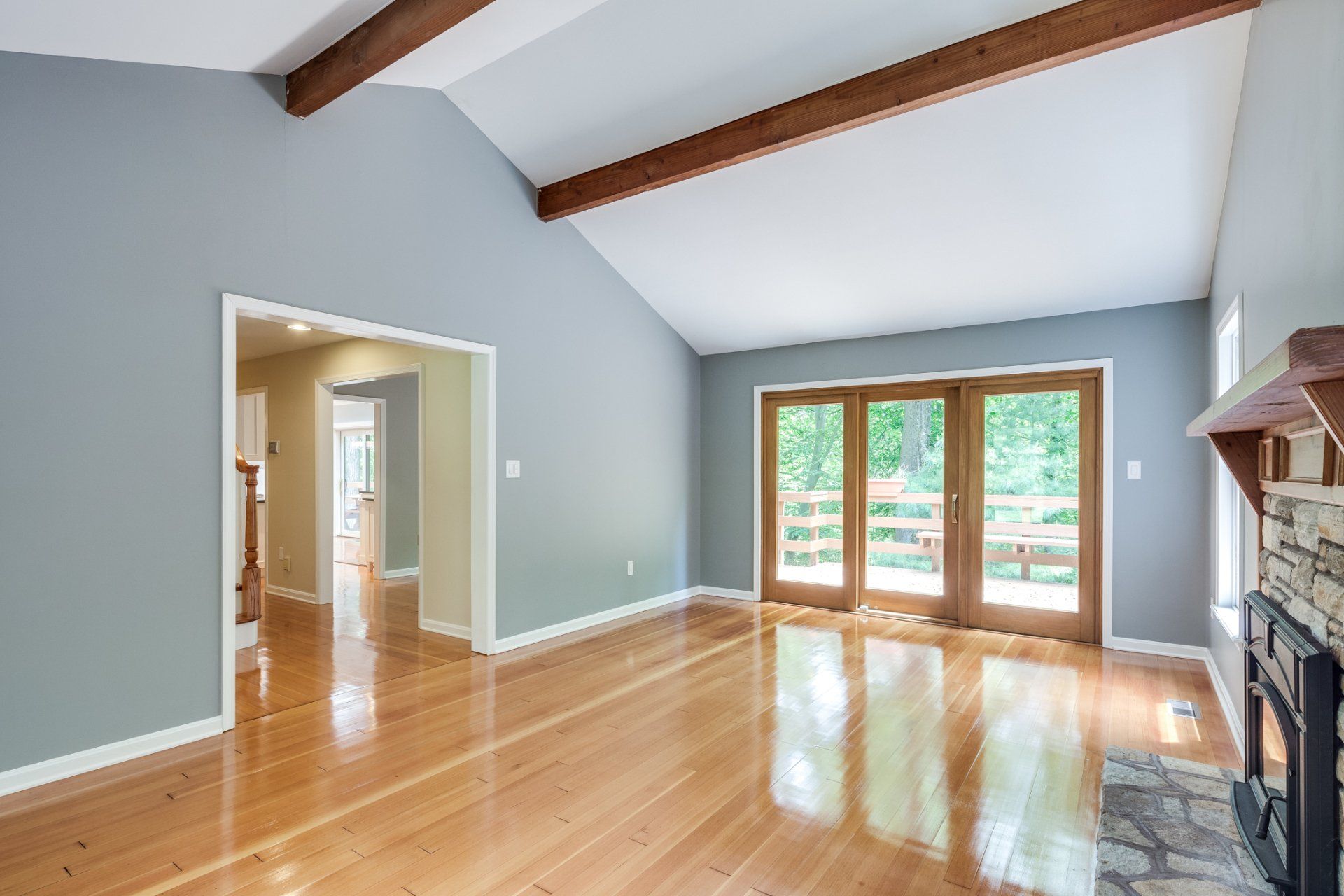 An empty living room with hardwood floors and a fireplace.