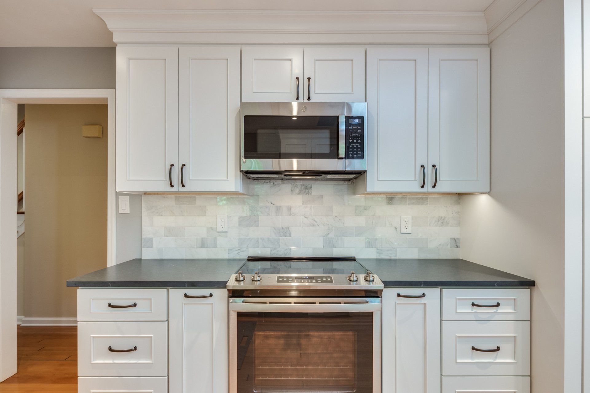 A kitchen with white cabinets and stainless steel appliances