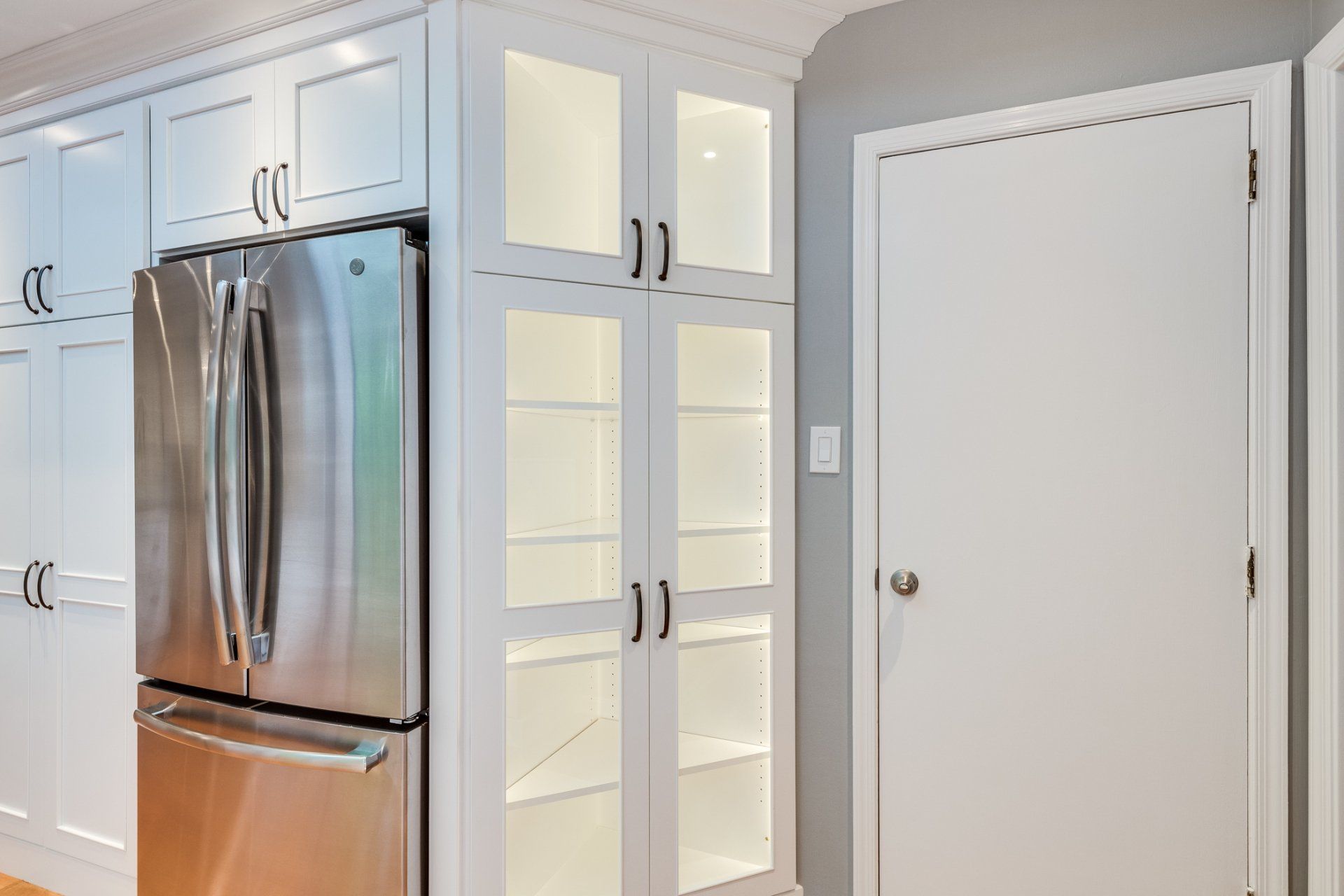 A kitchen with stainless steel appliances and white cabinets.