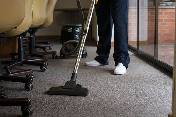 Man Vacuuming the Carpet — Redding, CA — Peerless Building Maintenance Man Vacuuming the Carpet — Redding, CA — Peerless Building Maintenance
