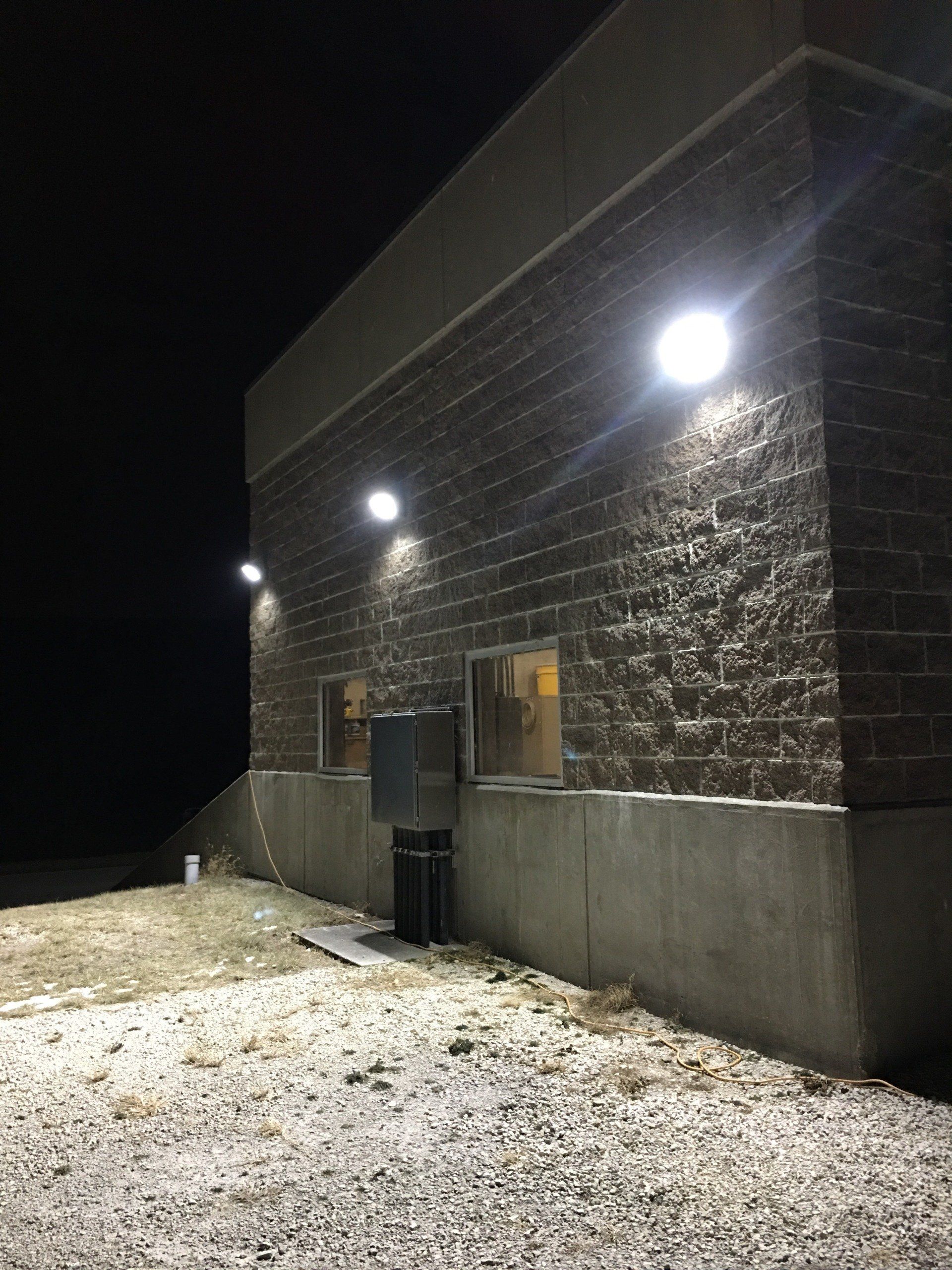 A brick building with lights on the side of it at night.