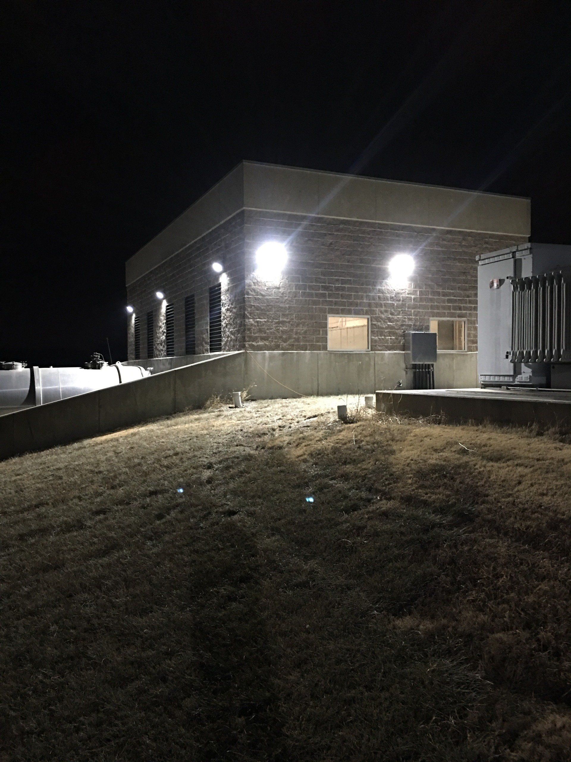 A large building is lit up at night with a ramp leading to it