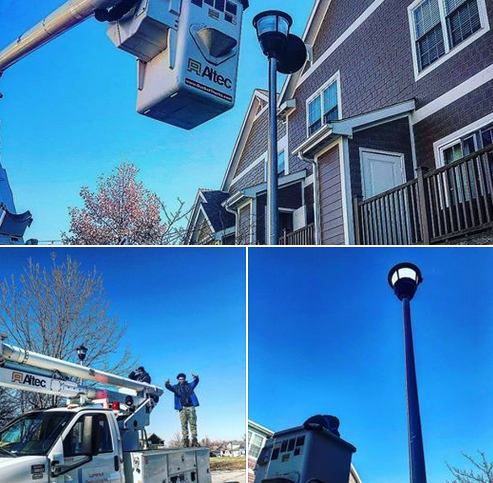 A man in a bucket is working on a street light