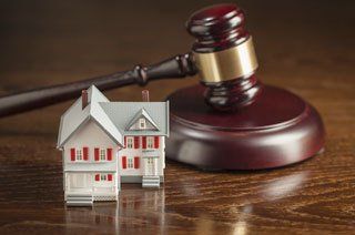 judge's gavel next to miniature house