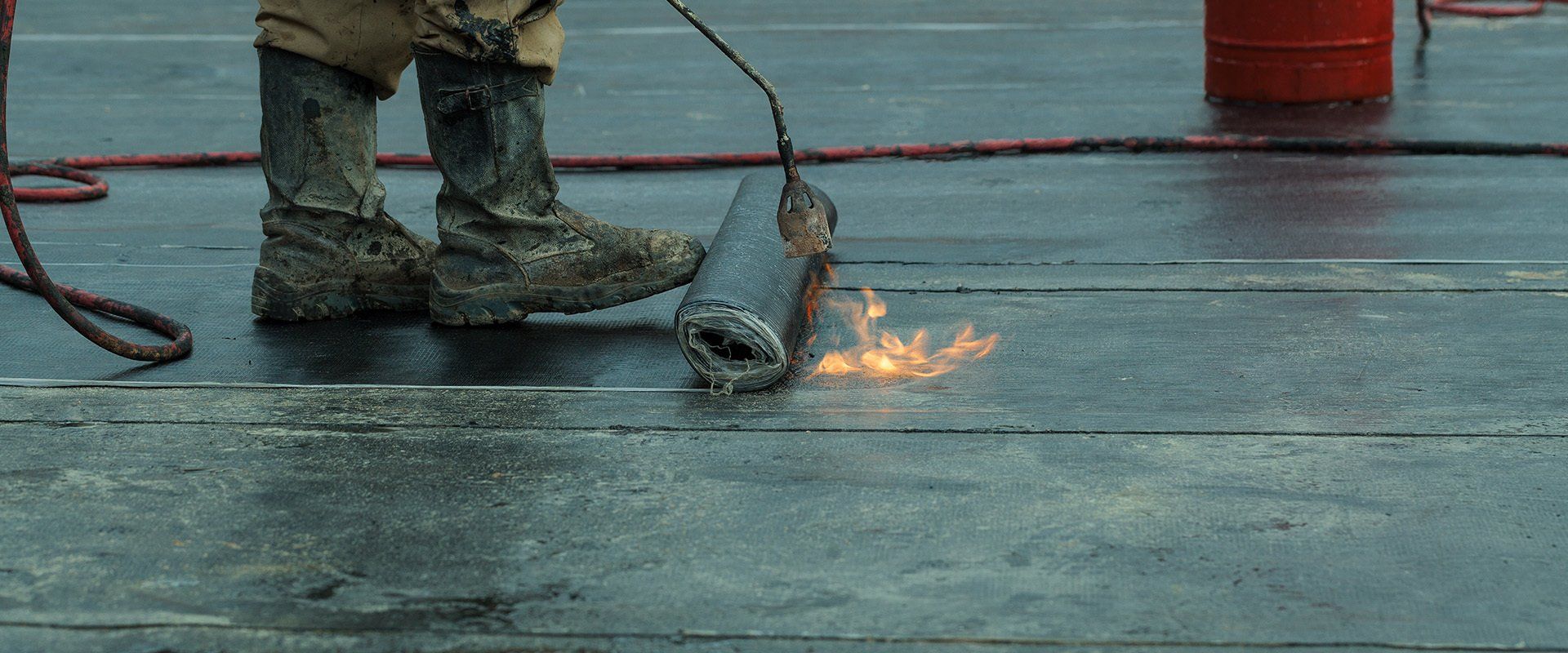 Una persona che usa una torcia per lavorare su una superficie di legno, con le fiamme visibili. 
