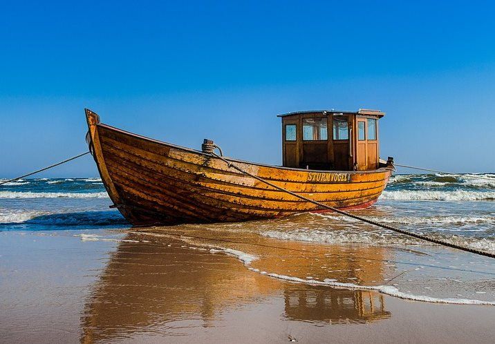 pixabay, lizenzfrei Ein Holzboot liegt am Strand in der Nähe des Meeres.