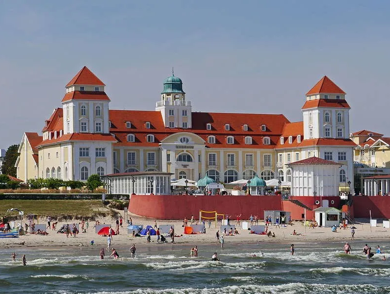 pixabay, lizenzfrei Ein großes Gebäude mit einem roten Dach steht oberhalb eines Strandes.