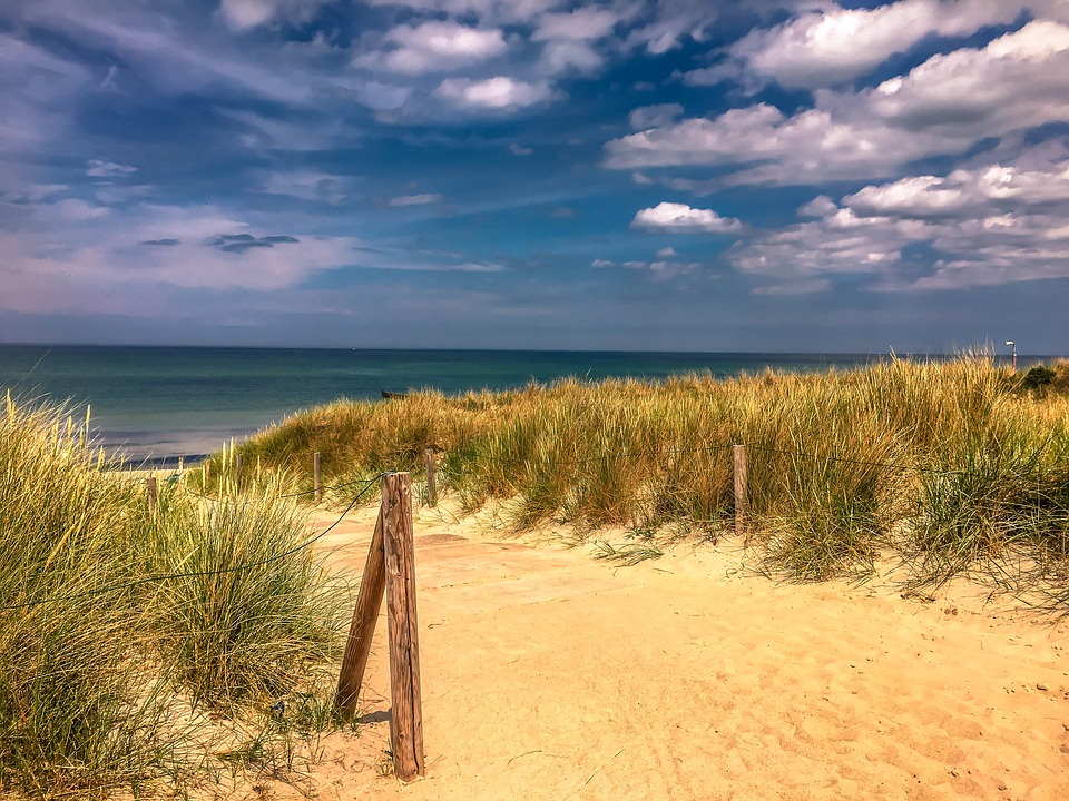 pixabay, lizenzfrei Ein Weg, der zum Meer führt, mit einem Holzpfosten im Vordergrund.