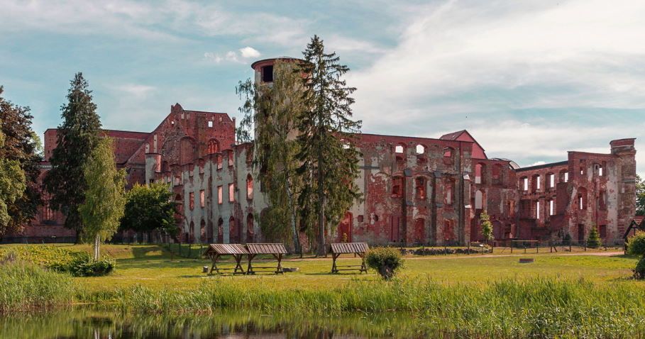 pixabay, lizenzfrei In der Mitte eines Feldes neben einem See steht ein großes Gebäude.
