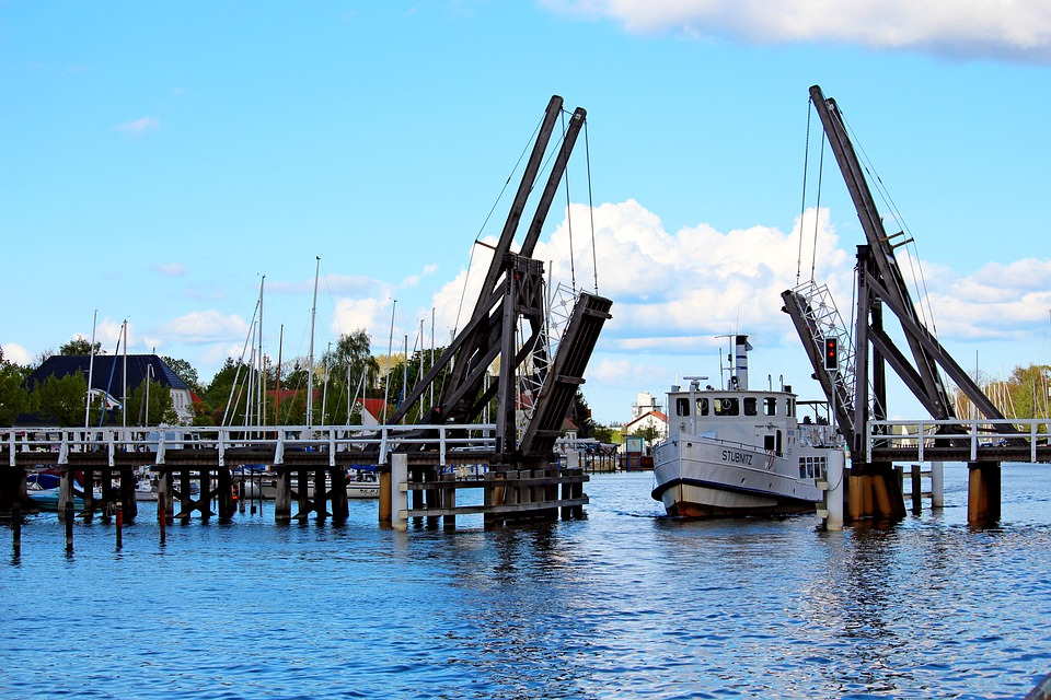pixabay, lizenzfrei Ein Boot liegt unter einer Brücke über einem Gewässer angedockt