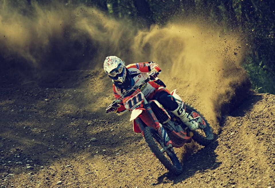pixabay, lizenzfrei Ein Mann fährt mit einem Dirtbike auf einer unbefestigten Straße.