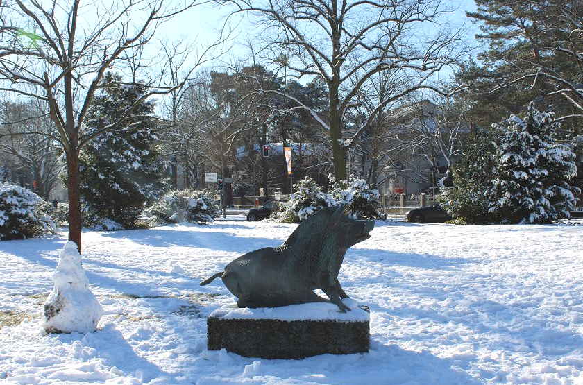 lizenzfrei Eine Statue eines Stiers sitzt im Schnee in einem Park