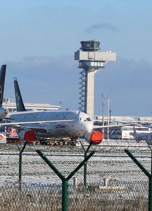 Bild ist lizenzfrei Mehrere Flugzeuge stehen auf einer verschneiten Landebahn mit einem Turm im Hintergrund