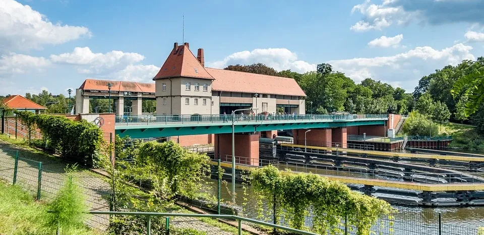 pixabay, lizenzfrei Eine Brücke über einen Fluss mit einem Gebäude im Hintergrund.