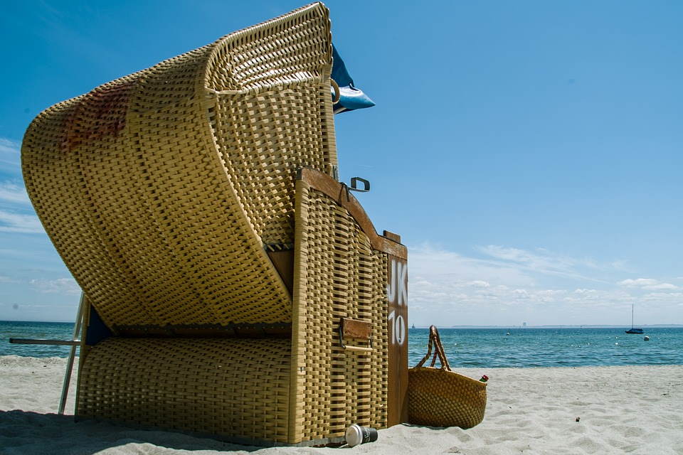 pixabay, lizenzfrei Ein geflochtener Strandstuhl steht auf dem Sand in der Nähe des Ozeans