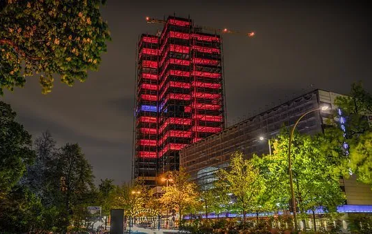 pixabay, lizenzfrei Ein hohes Gebäude mit roten Lichtern ist nachts beleuchtet.