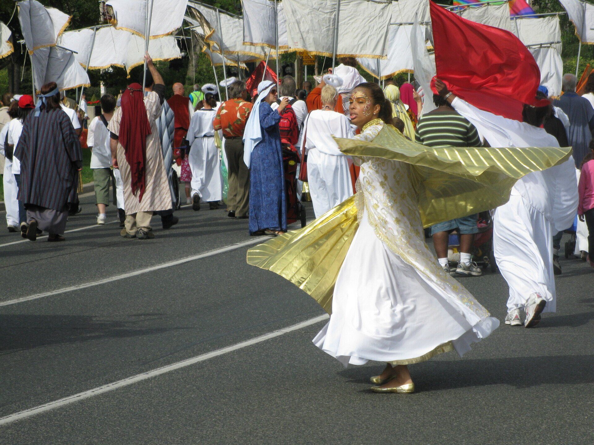 A woman in a white dress is dancing in a parade