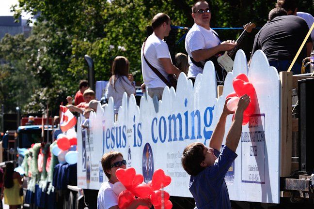 A parade with a sign that says jesus is coming