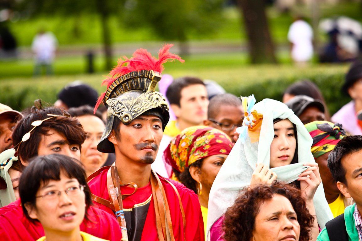 A man in a helmet is standing in a crowd of people.