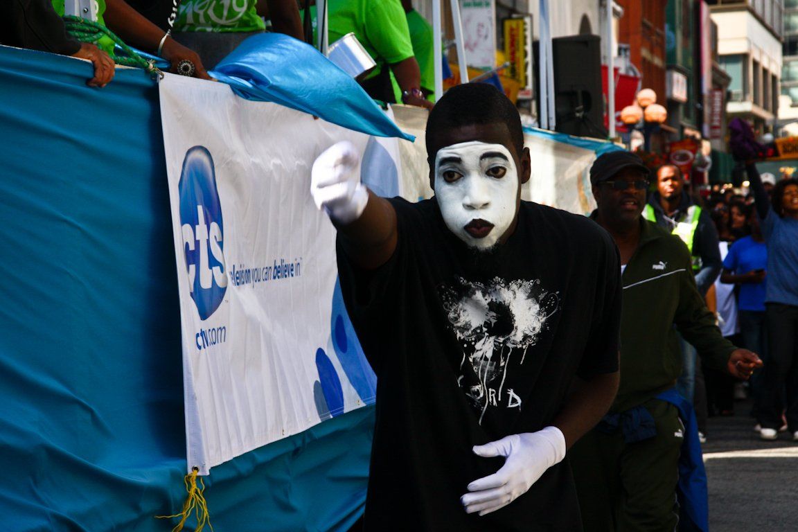 A man in a mime costume stands in front of a cbs banner