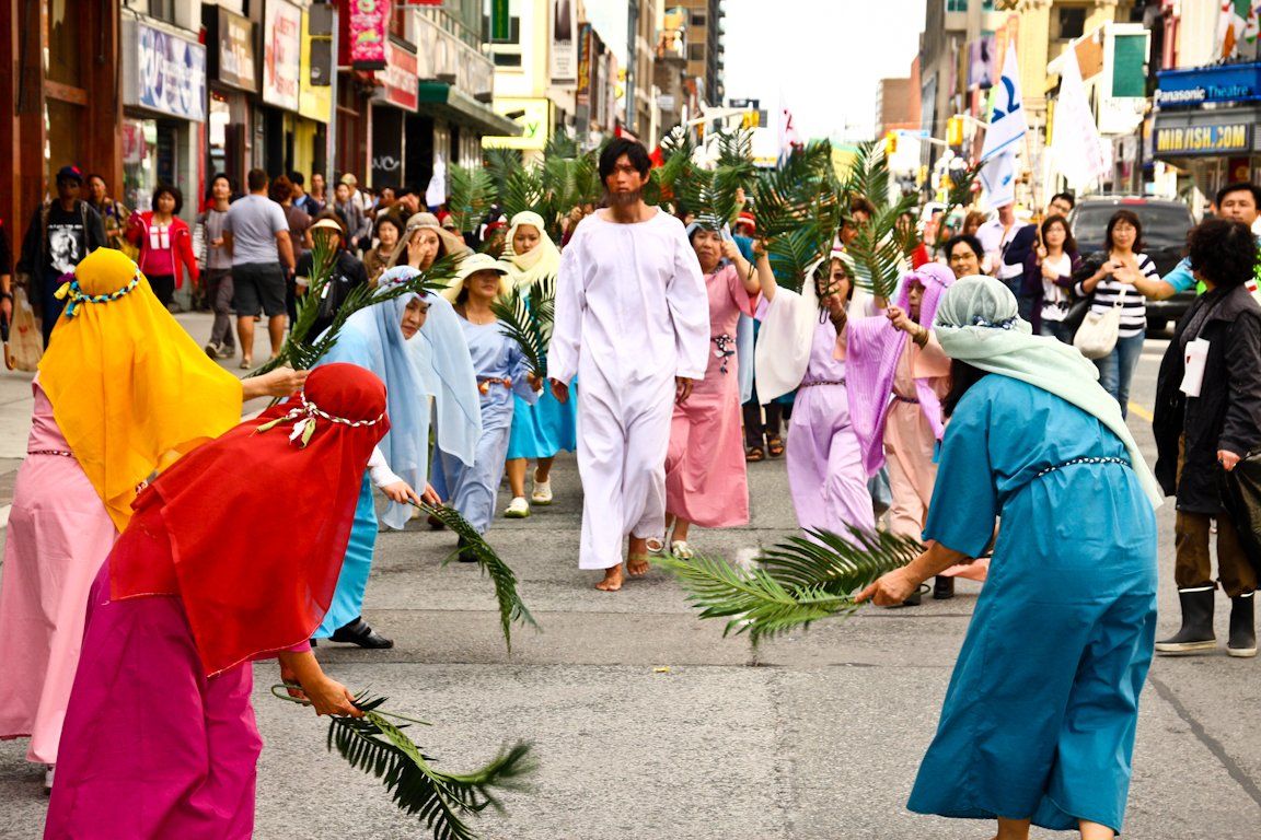A group of people dressed in costumes are walking down a street.