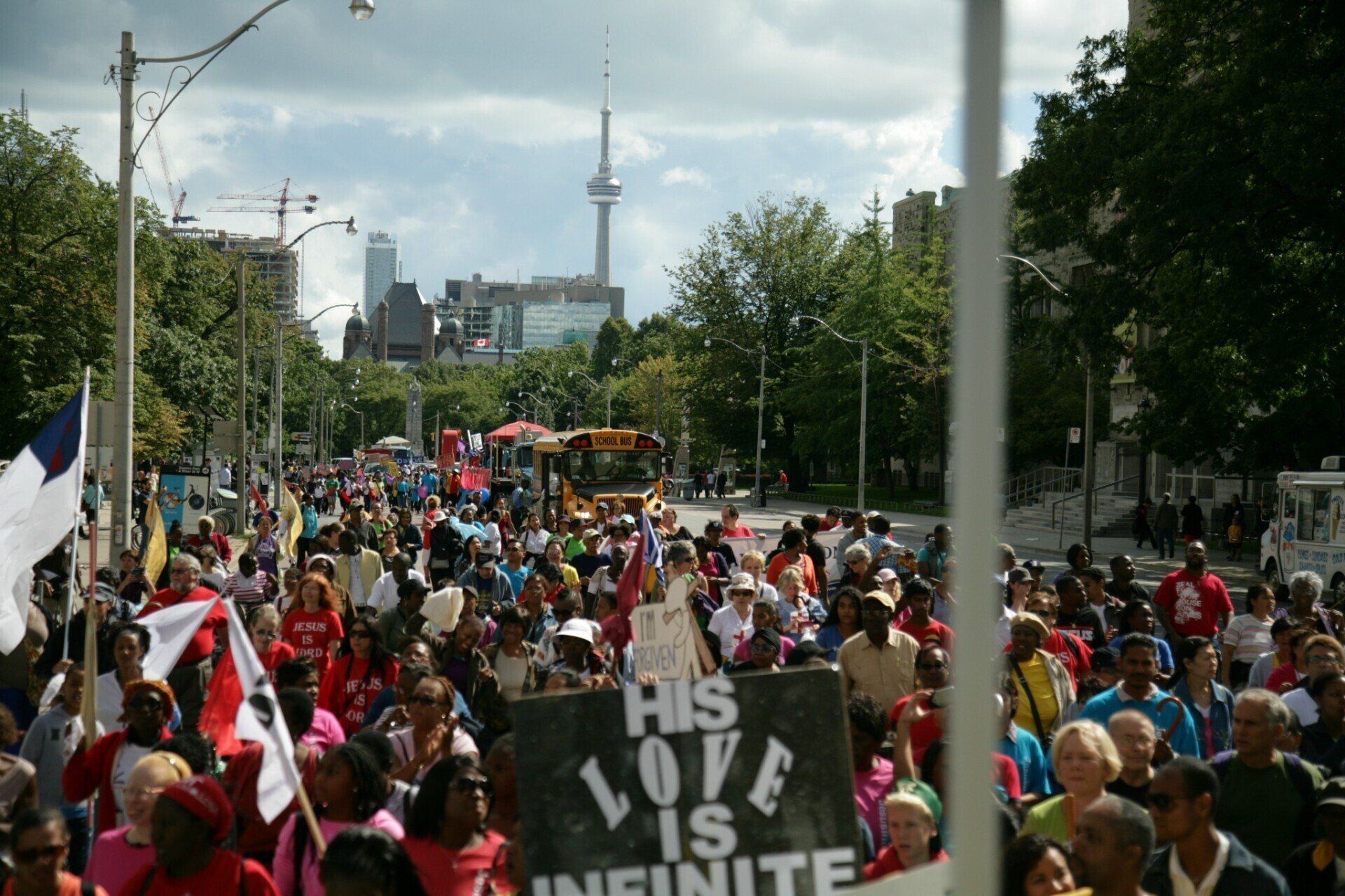 A crowd of people holding a sign that says his love is infinite