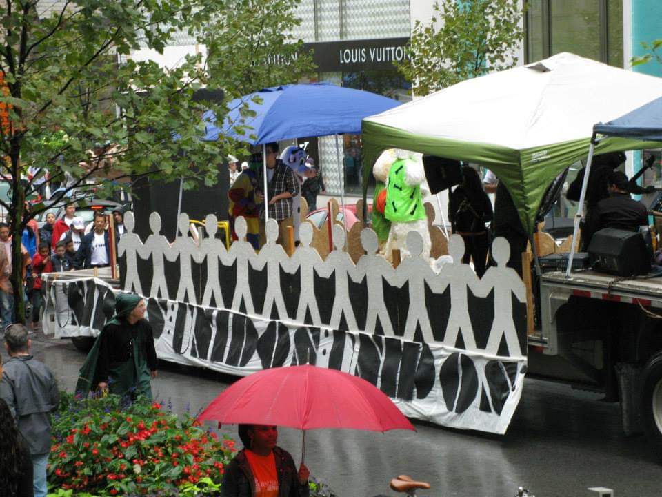 A louis vuitton store is visible in the background of a parade