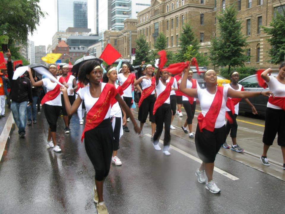 A group of people are marching down a street in the rain