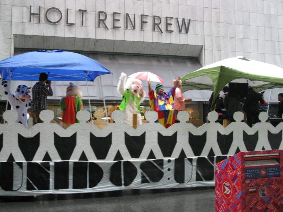 A group of people on a float in front of holt renfrew