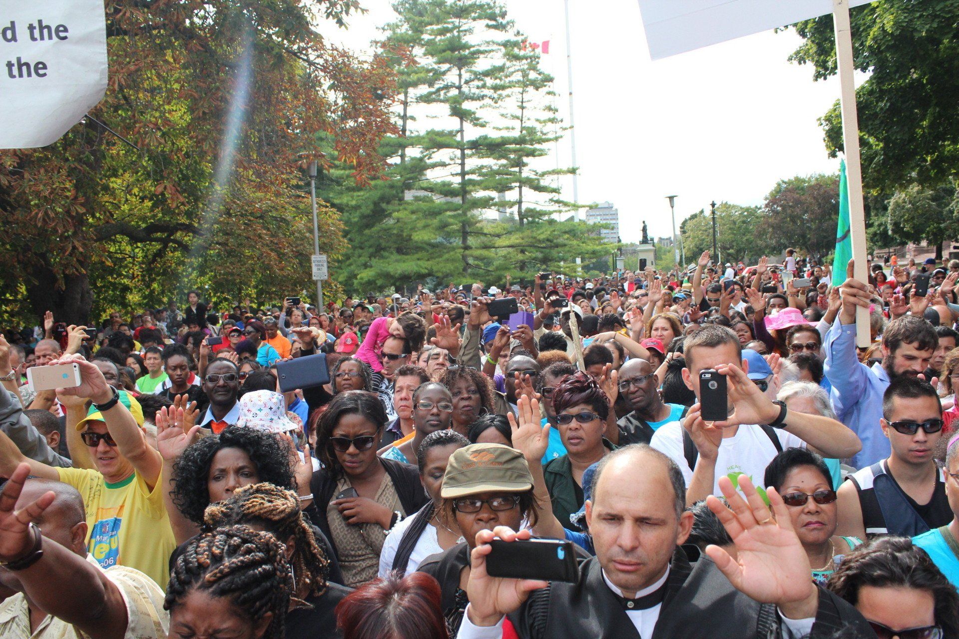 A crowd of people holding up signs including one that says 