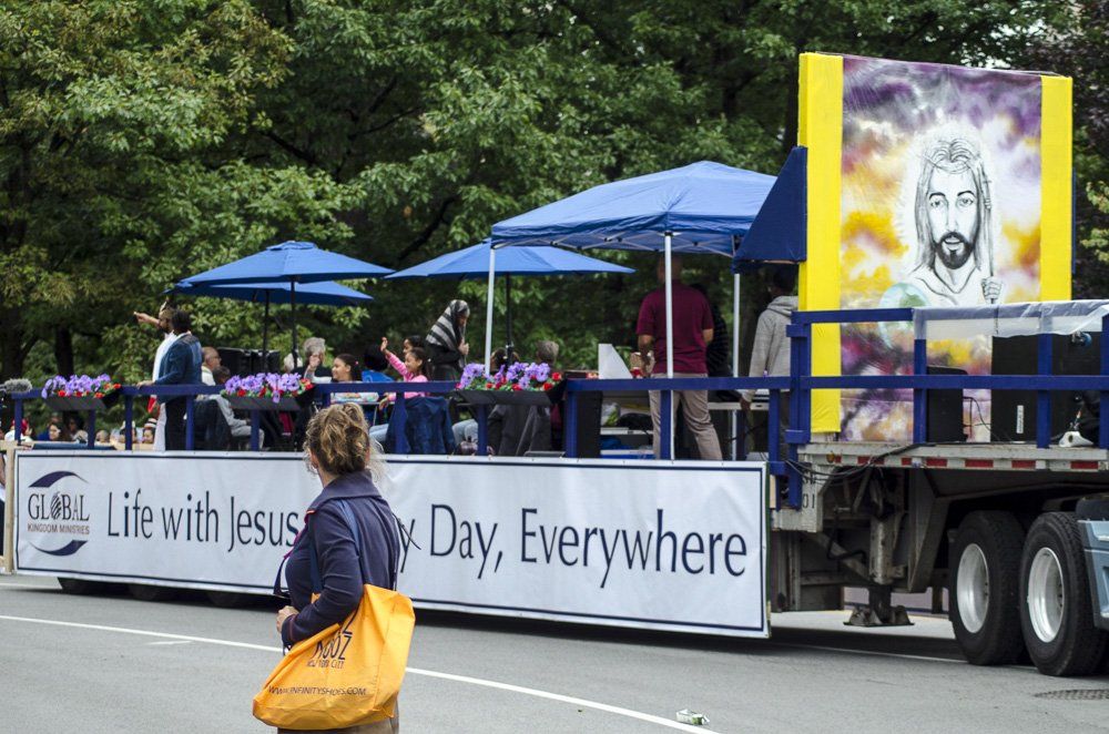 A woman stands in front of a sign that says life with jesus day everywhere