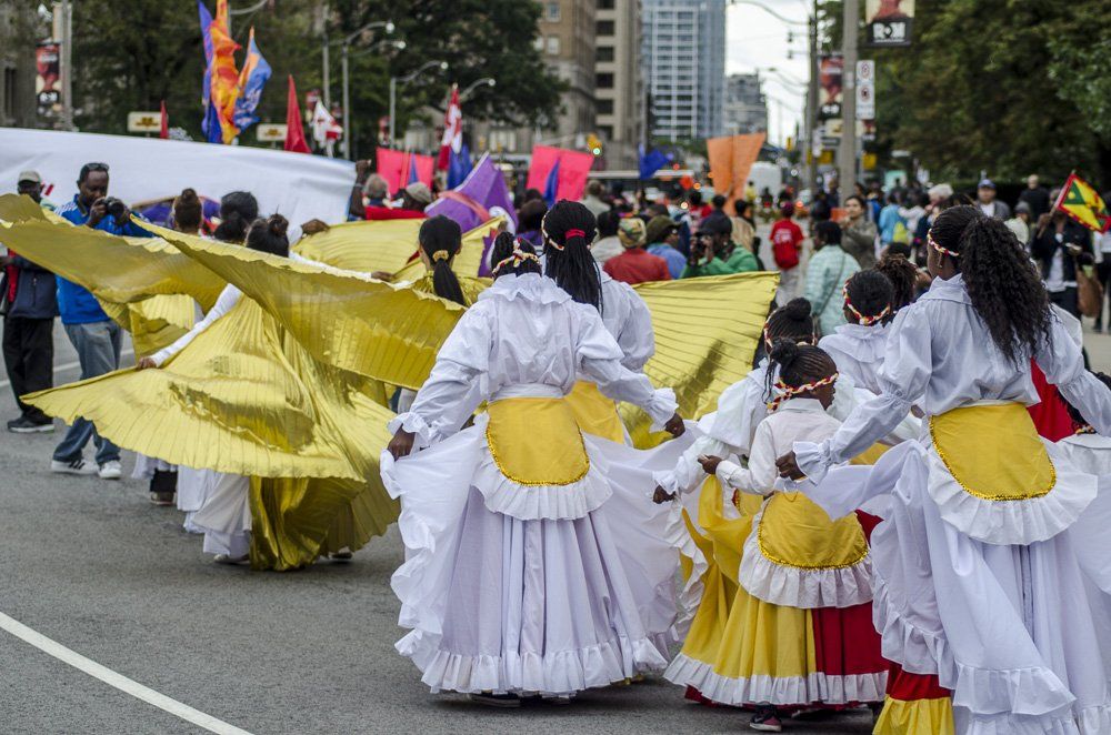A group of people are dancing in a parade.
