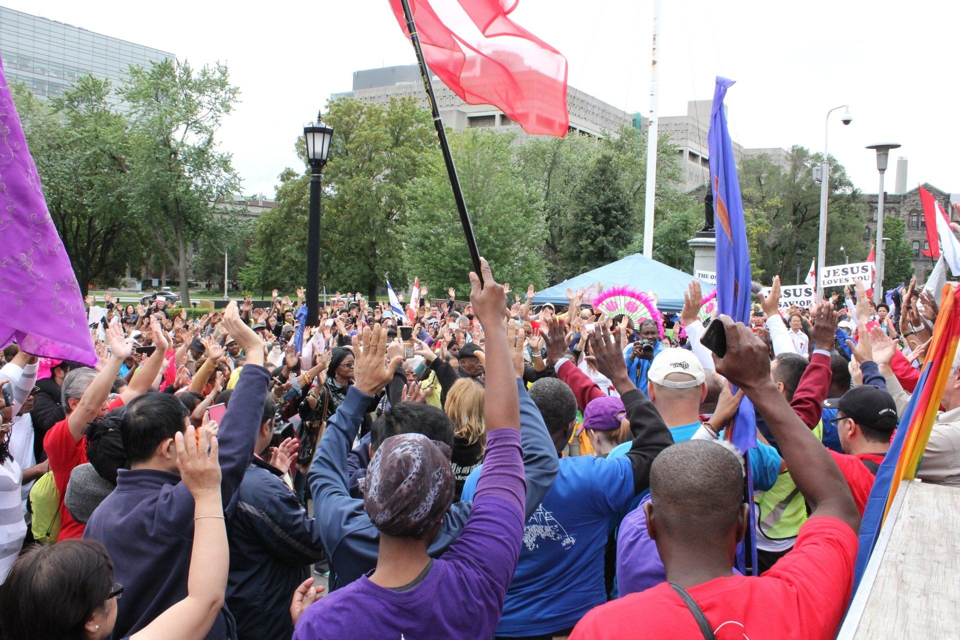 A crowd of people raising their hands in the air at a protest