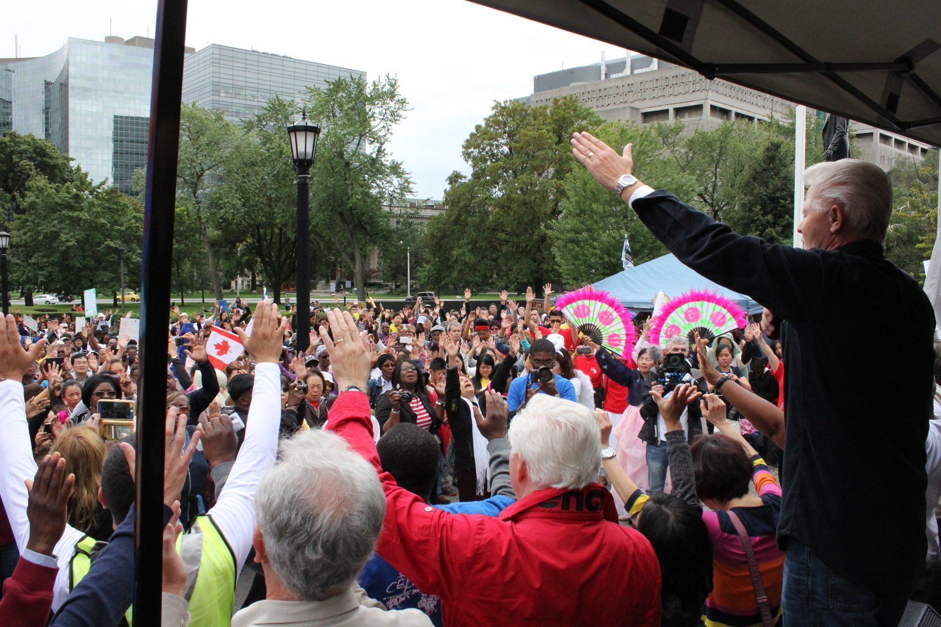 A man is standing in front of a crowd with his hands in the air
