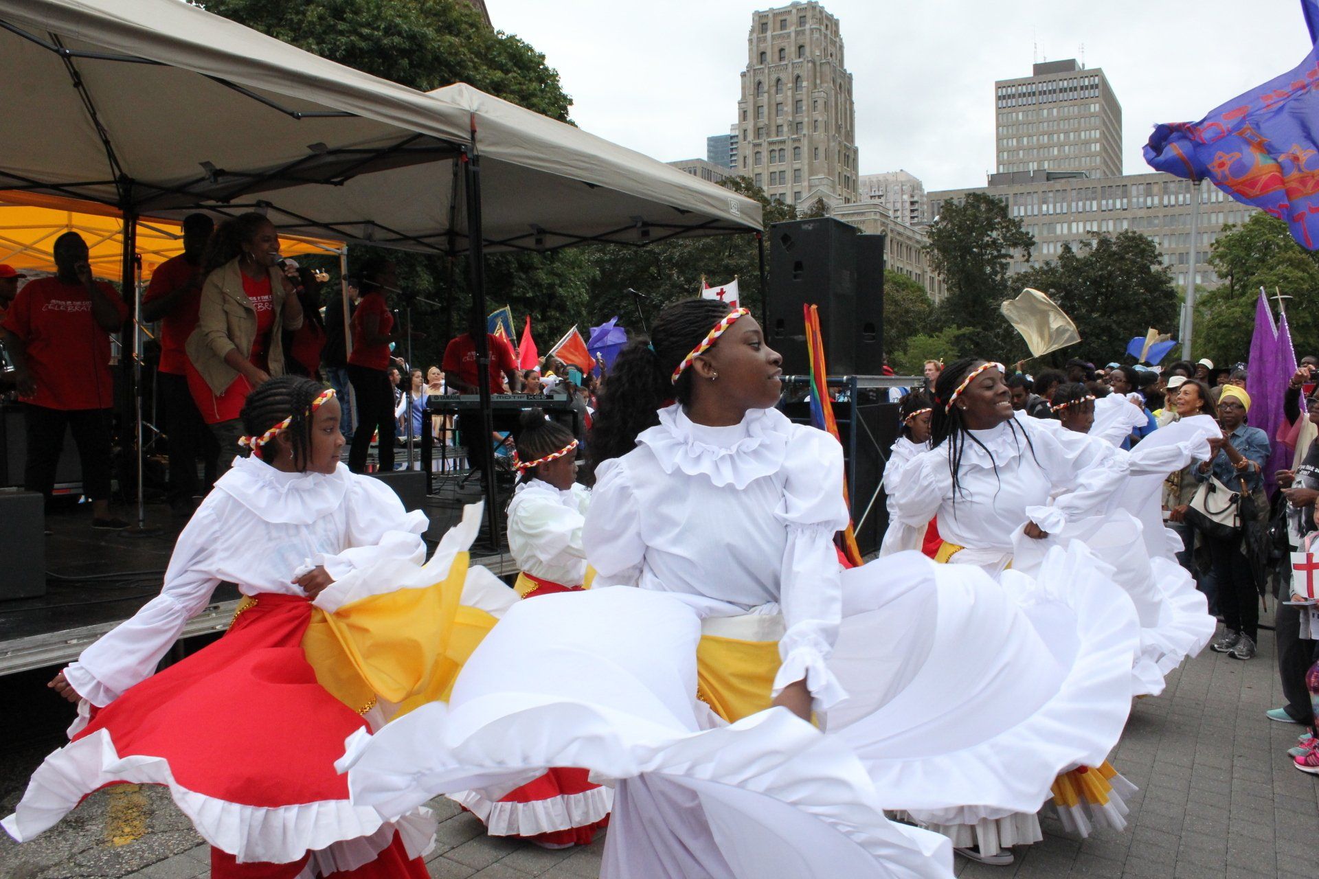 A group of women in colorful dresses are dancing in a parade.