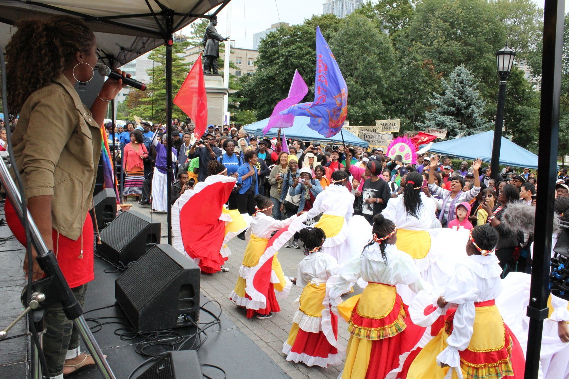 A woman singing into a microphone in front of a crowd of people