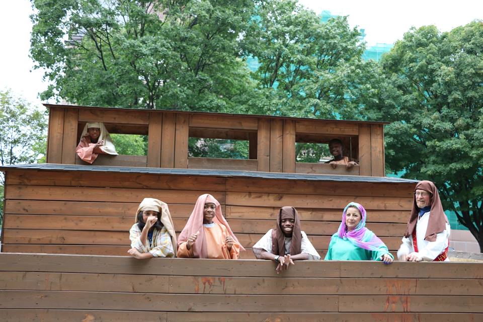 A group of people standing on top of a wooden structure