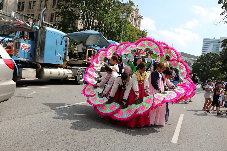 A group of people are walking down a street in front of a truck