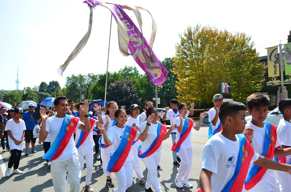 A group of people are marching down a street in a parade.