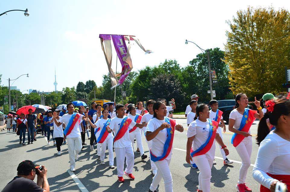 A group of people are marching down a street in a parade