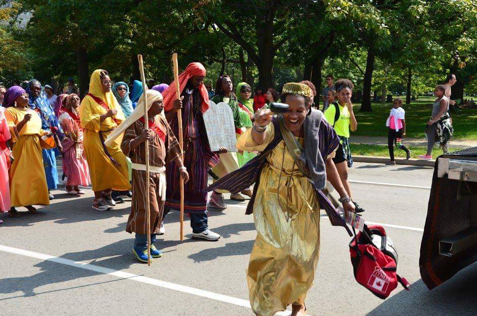A group of people dressed in costumes are walking down a street.