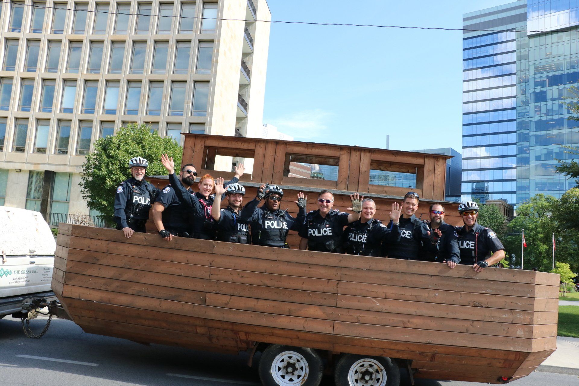 A group of police officers are riding on the back of a wooden boat