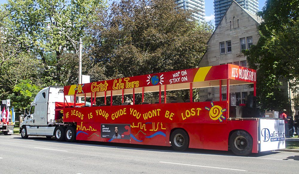 A red double decker bus is parked on the side of the road