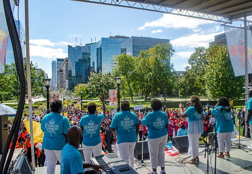 A group of people are singing on a stage in front of a crowd.