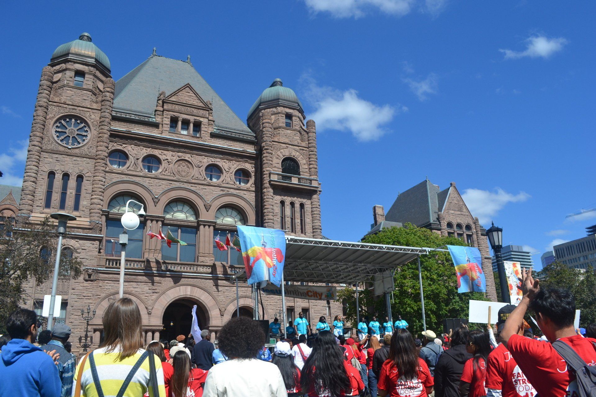 A crowd of people are gathered in front of a large brick building