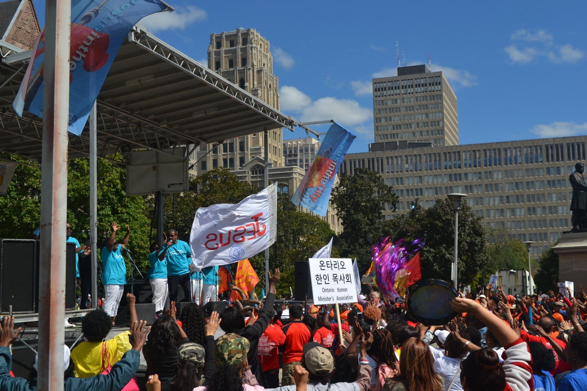 A crowd of people are gathered in front of a stage at a protest.