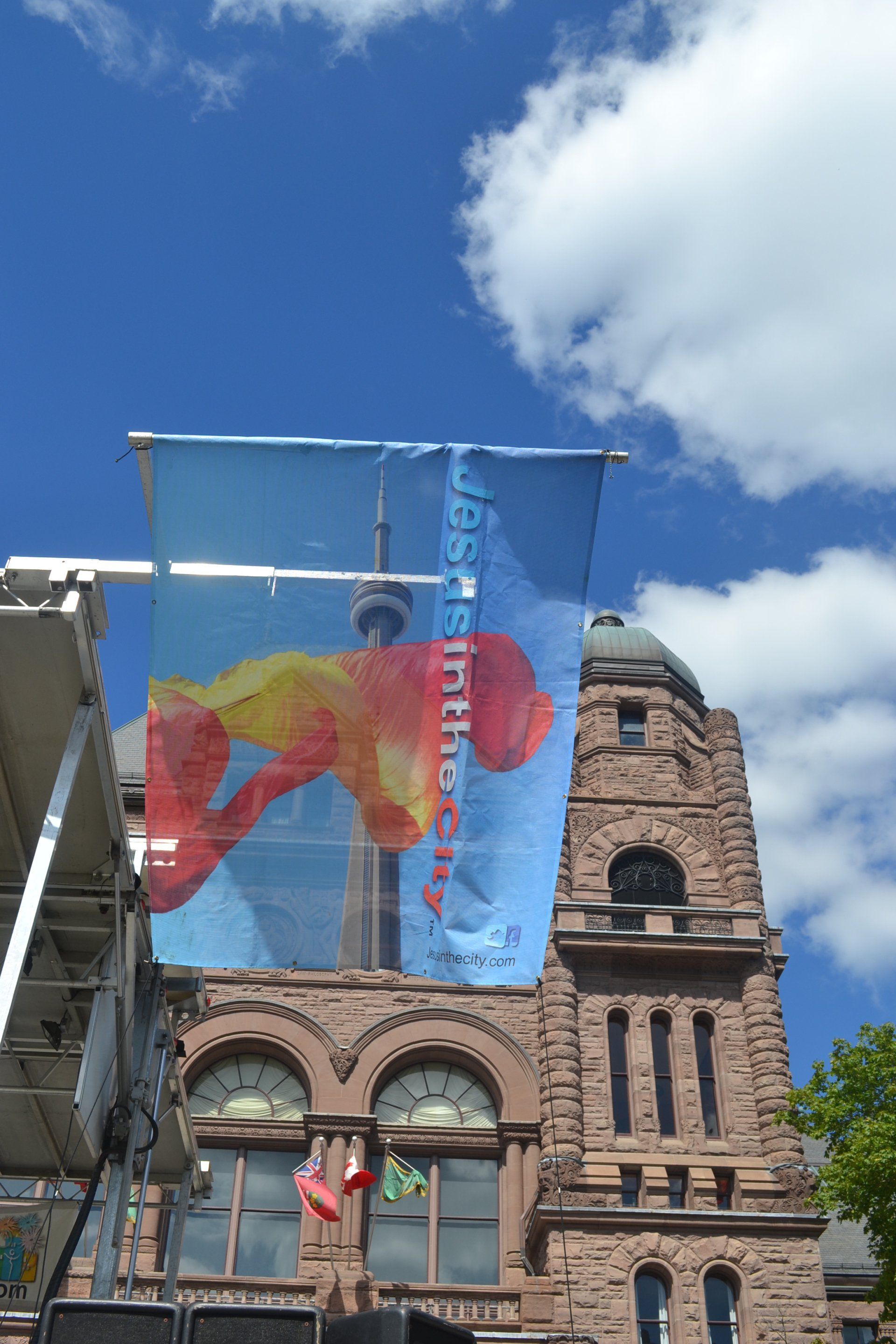 A large banner with a fish on it is hanging from a pole in front of a building.