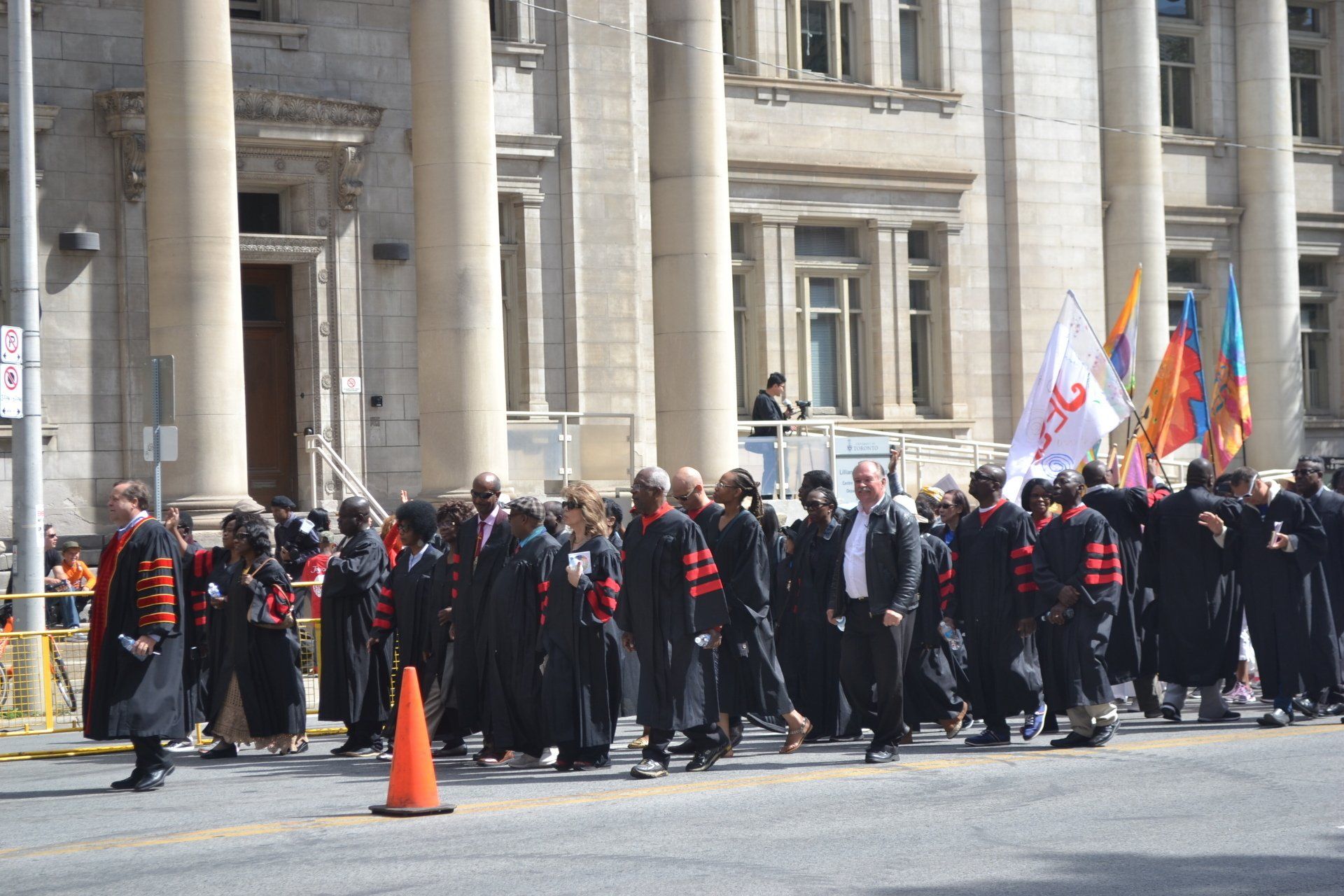 A group of people are marching down a street in front of a building
