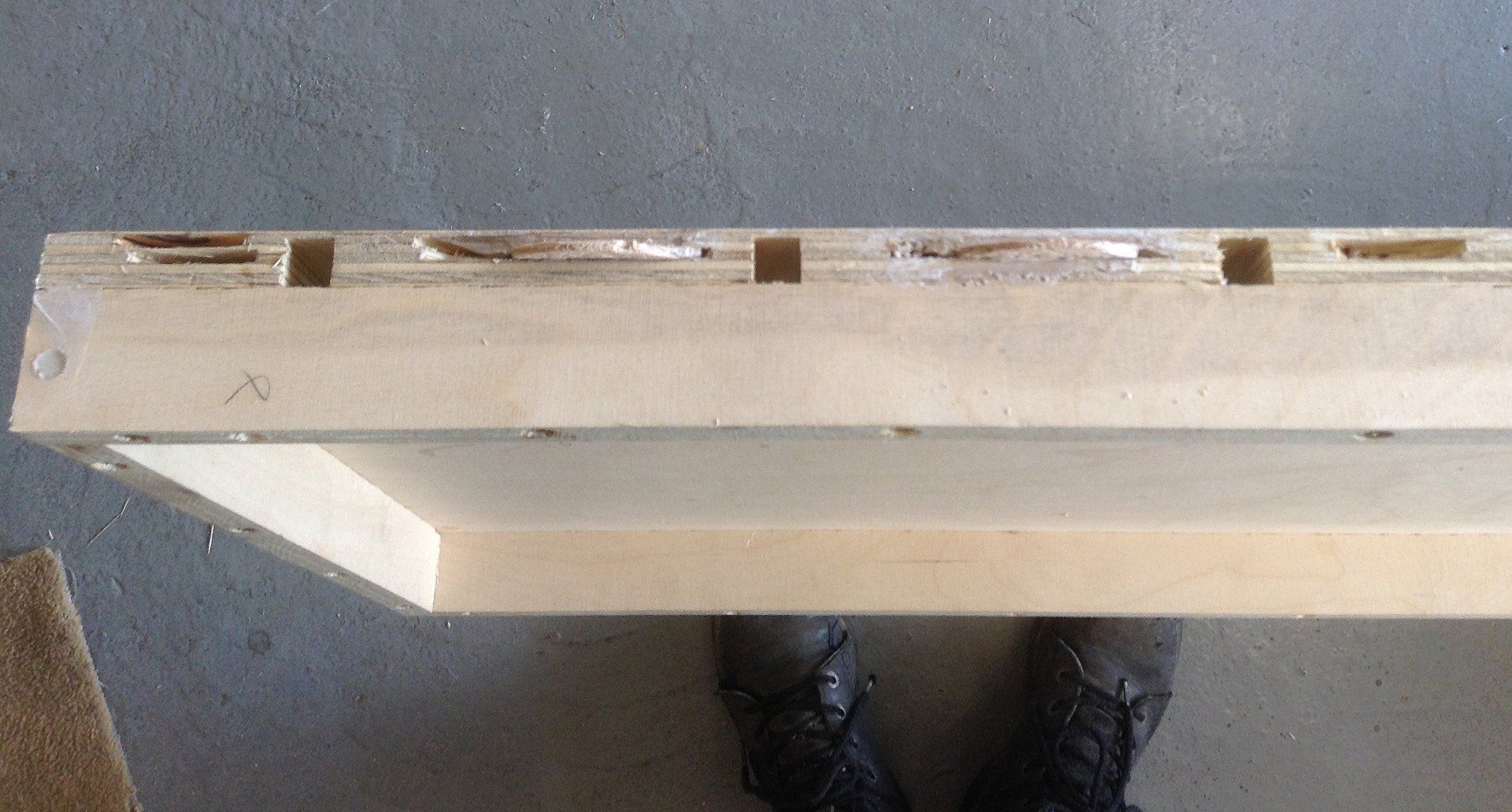 A person is standing next to a piece of wood.